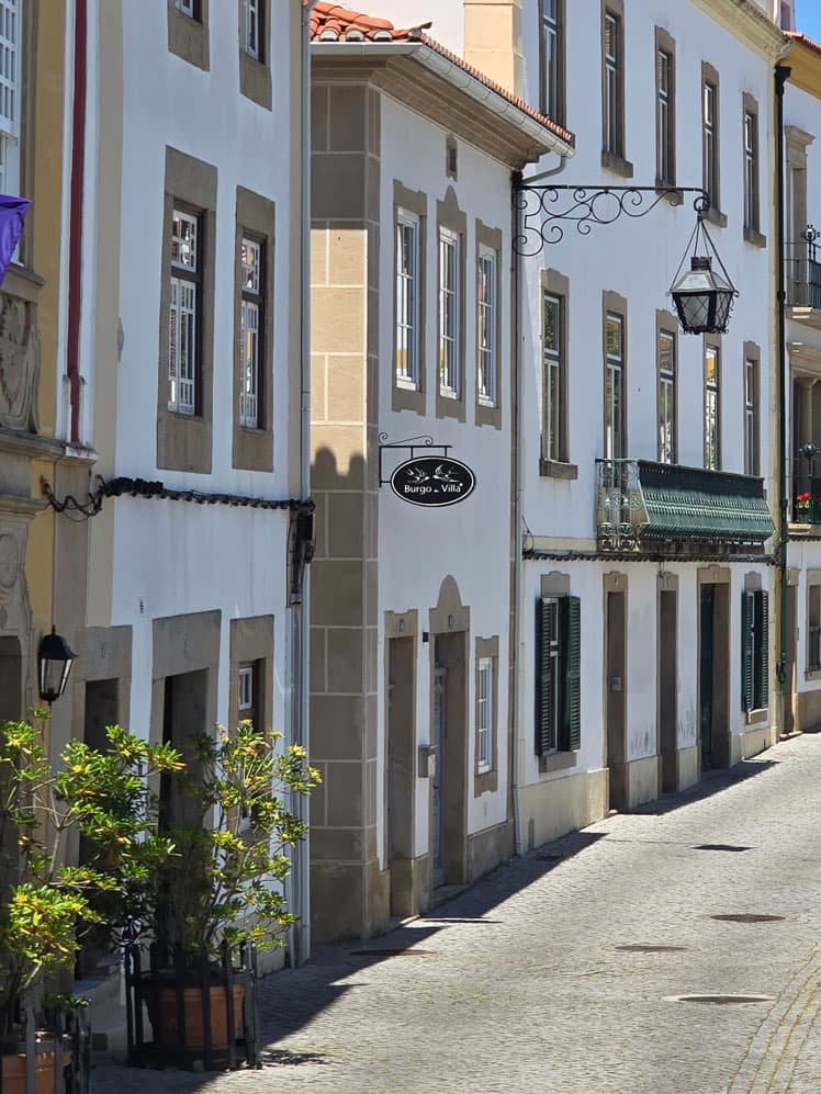 Uma rua estreita de casas caiadas com lanternas de ferro forjado