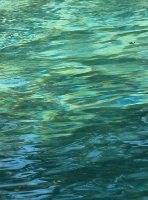 Água turquesa e transparente a ondular na piscina natural
